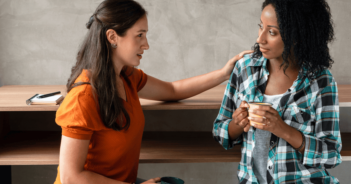 Dos mujeres conversando en actitud de apoyo ante una situación de lesbofobia.