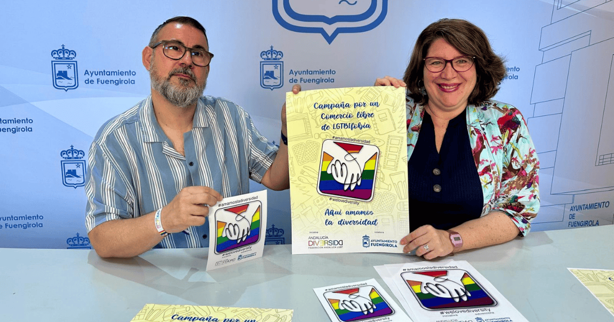 Antonio Ferre y Cristina Bornao sosteniendo el cartel y los distintivos en vinilo de la campaña Comercio libre de LGTBIfobia en Fuengirola.